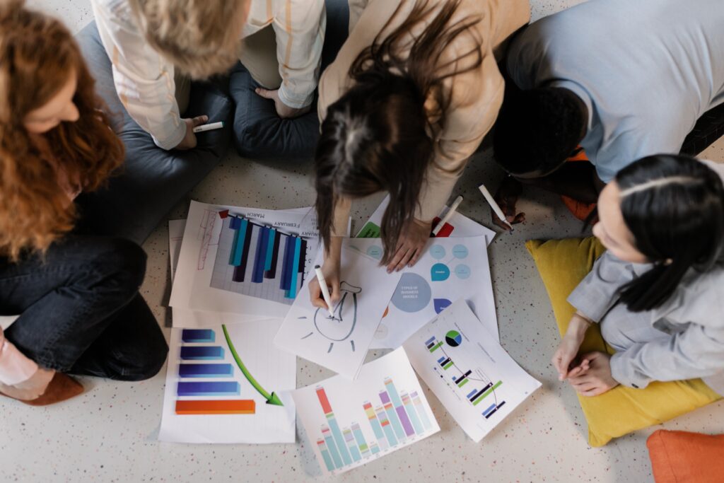 A team of managers, united in their determination, huddles over documents and graphs, their expressions etched with focus as they try to find a solution to address business challenge they are experiencing. They are prime example of a business that needs a problem solving technique for solving business problems rapidly